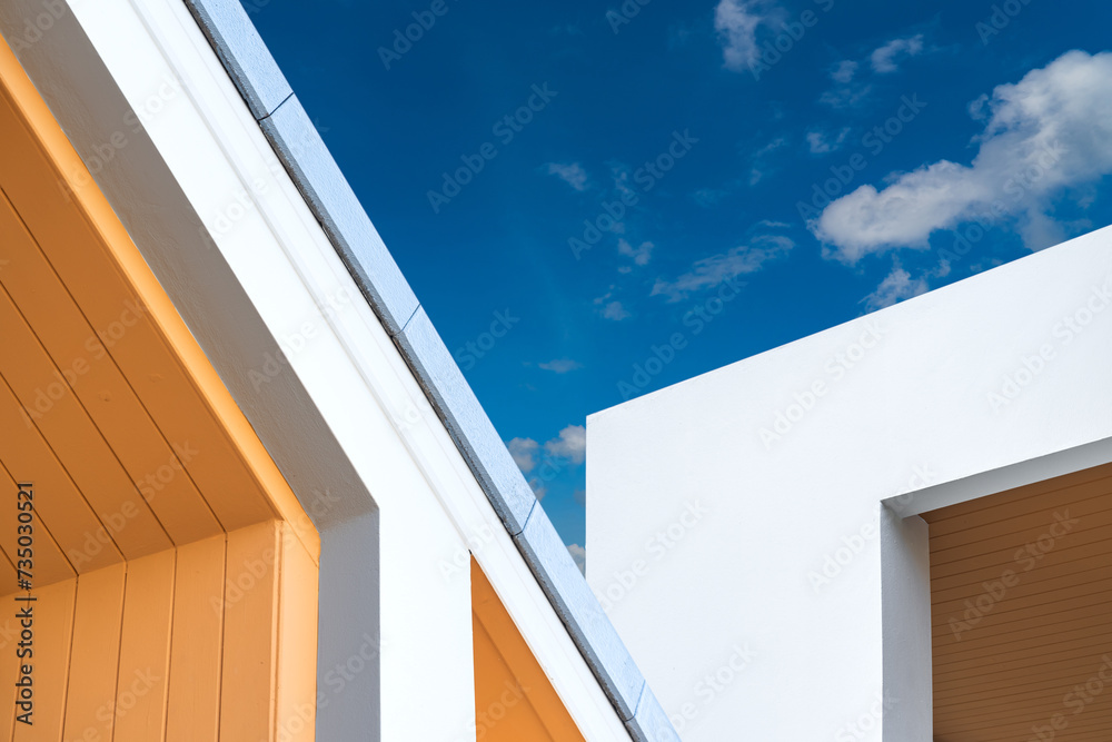 White building wall and roof top against blue sky White building wall and roof top against blue sky