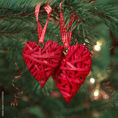 Valentine's Day background with two hanging heart shapes on Christmas tree.