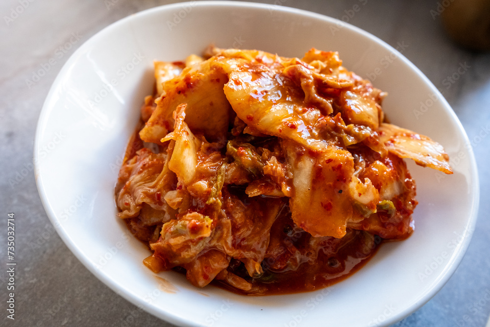 kimchi in fresh white bowl close-up on gray background
kimchi in fresh white bowl close-up on gray background