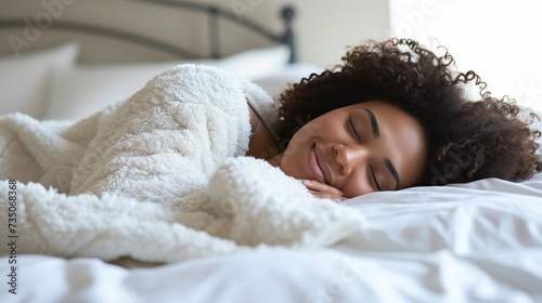 Young african american woman in white clothing blissfully sleeping on white bed with white blanket