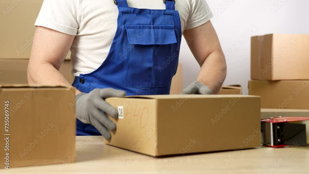 Worker sealing box with tape for moving, close-up Worker sealing box with tape for moving, close-up