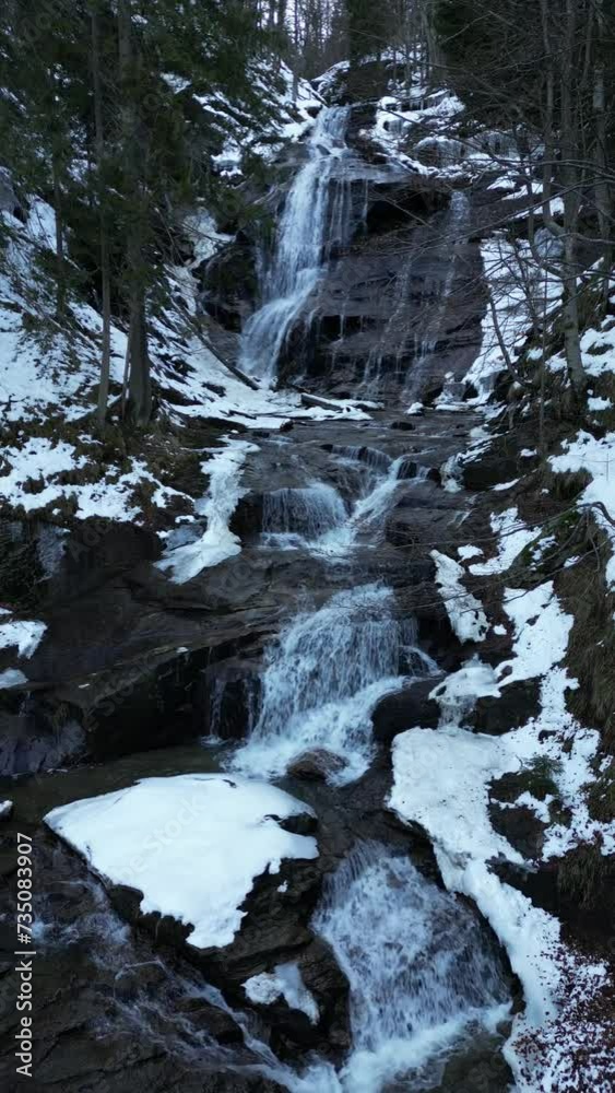 View of a waterfall during winter. Cold and frost in the forest. Winter adventure and hiking. Kozice Waterfall near Fojnica in Bosnia and Herzegovina. View of a waterfall during winter. Cold and frost in the forest. Winter adventure and hiking. Kozice Waterfall near Fojnica in Bosnia and Herzegovina.