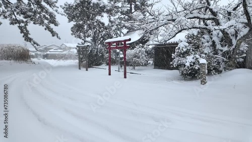 Heavy snow on torii gates at small shine in Japanese village