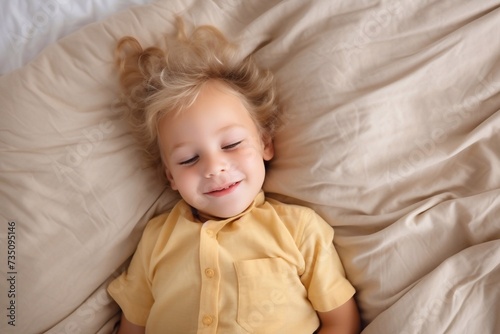Upper view copy portrait of cute blond baby sleeping in bed on his back, feeling safe, watching sweet dreams, resting, growing, gaining strength, getting strong. Child Care concept. Nap time