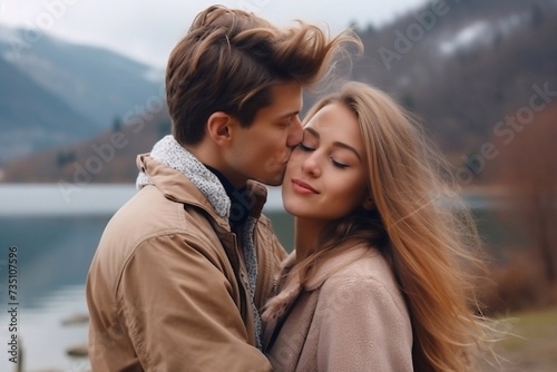 A guy kisses a girl and hugs near a lake and mountains. close-up, vertical, horizontal photo