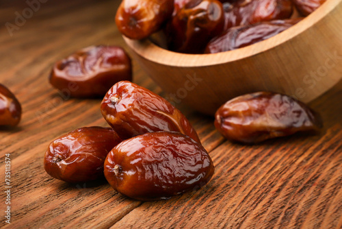 Dates fruits scattered on a wooden table close-up.