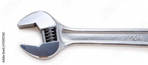 A close up of a nickel adjustable wrench, a metalworking hand tool, on a white background. It is a versatile household hardware and kitchen utensil made of composite material. photo