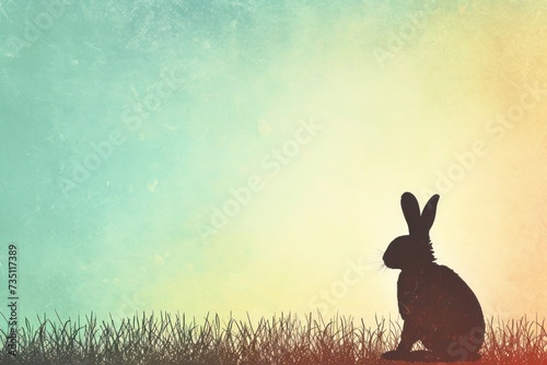 A terrestrial animal, Rabbit, sitting in grass, silhouette against the sky