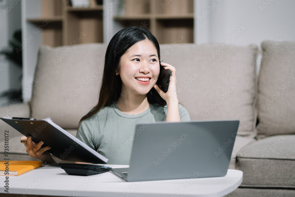 Consulent speaking to mobile cellphone at home office. women speak with remote clients using phone. Laptop on the desk. Home office smart working concept lifestyle. Consulent speaking to mobile cellphone at home office. women speak with remote clients using phone. Laptop on the desk. Home office smart working concept lifestyle.