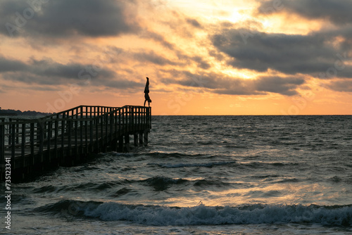 Athletischer Mann macht Handstand auf Steg an der Ostsee. photo