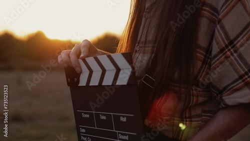 Cinematography take clapper in the hands of a man close-up in the setting sun  photo