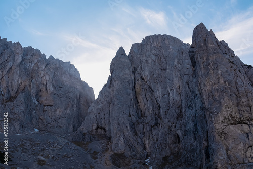 Panoramic view of majestic mountain cliff Schartenspitze in untamed Hochschwab mountain region, Styria, Austria. Scenic hiking trail in shadows in remote Austrian Alps. Wanderlust in alpine summer photo