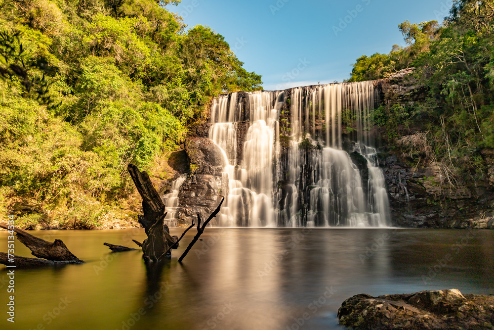 Obraz premium Waterfall with forest, rocks and vegetation