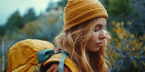 A woman wearing a yellow hat and backpack. Suitable for travel and adventure themes photo