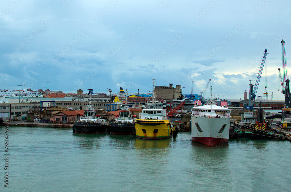 Panoramic landscape view of commercial docks with moored ships in port of Livorno. Import, export and business logistic. International water transport