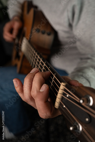 A closeup shot of a man's hand playing the guitar 