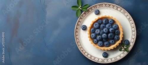 Top view on blueberry mini tart served on blue ceramic plate over gray textile napkin Top view Square image. Creative Banner. Copyspace image