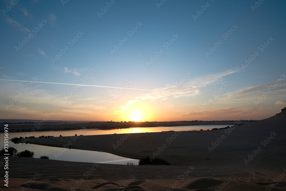 sunset scene on Magic Lake; where water comes out of deep earth & forms a lake in a heart of dessert in fayoum,  Egypt.