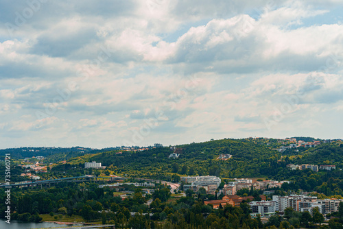A view of Coimbra City under a clear sky, with trees and buildings. Landscape background and wallpaper.