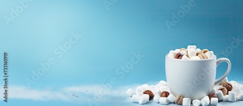 Mug of hot chocolate with marshmallows on a shabby blue surface. Creative Banner. Copyspace image