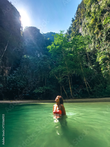 Young asian woman discovering secret lagoon. Summer vacation at Emerald Cave (Tam Morakot) at Trang and Krabi on her vacation at south of Thailand photo