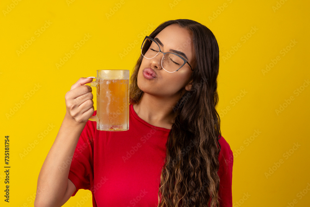woman with long curly hair wearing glasses and holding glass of cold beer woman with long curly hair wearing glasses and holding glass of cold beer