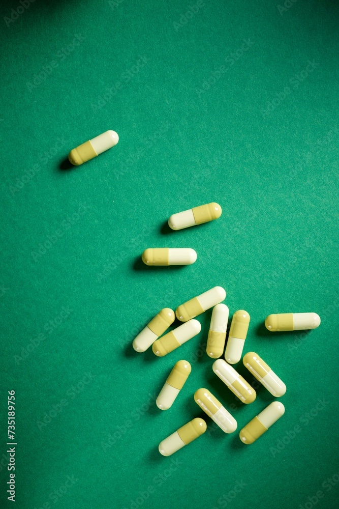 Medication capsules on a green table Medication capsules on a green table