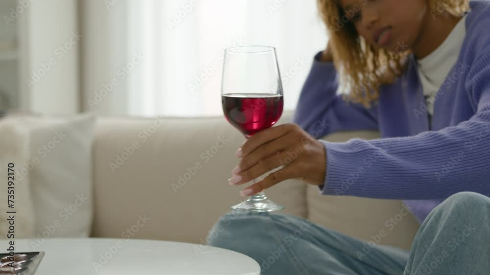 Pensive relaxed dreaming sad calm African American woman alcohol addict ethnic girl female at home alone relaxing think problem take glass of red wine beverage drink thoughtful looking at wineglass Pensive relaxed dreaming sad calm African American woman alcohol addict ethnic girl female at home alone relaxing think problem take glass of red wine beverage drink thoughtful looking at wineglass