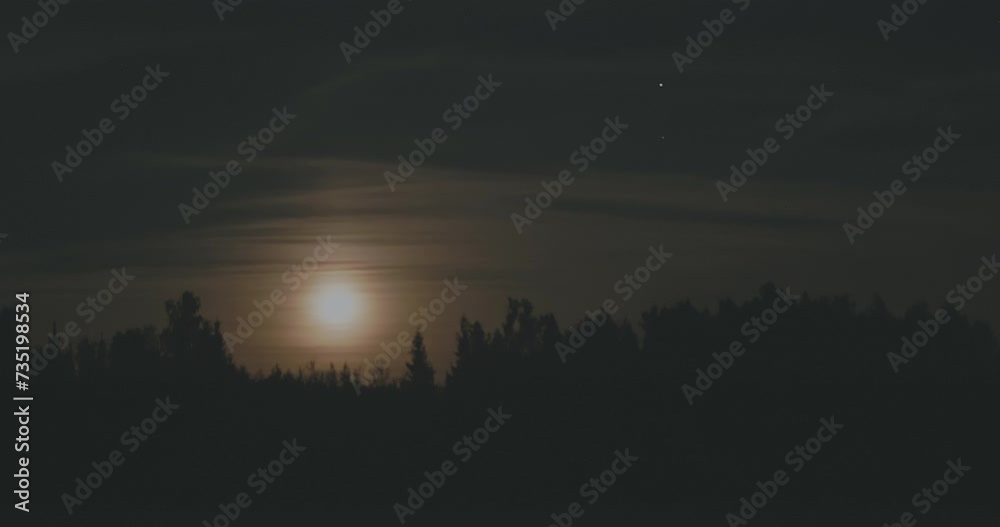 the sun is shining through the clouds over a forest at night the sun is shining through the clouds over a forest at night