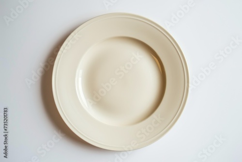 A white plate sitting on top of a white table. Perfect for food photography or minimalist design