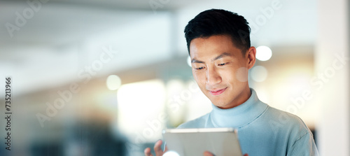 Asian man with tablet, smile and scroll, thinking and reading email, review or article at startup. Internet, research and happy businessman with digital app for with networking, social media or web. photo