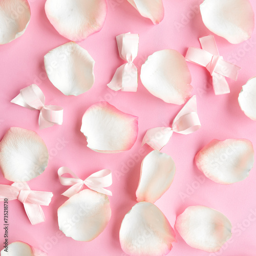 White rose petals on pastel pink background. Valentines Day or Wedding concept. Beautiful greeting card