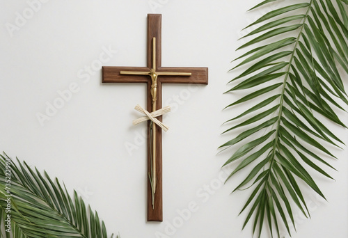 Wooden cross and palm leaf on white wall
