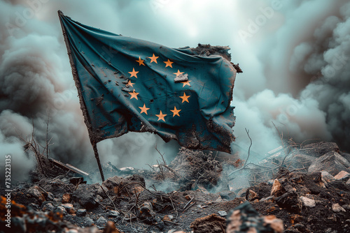 A tattered European Union flag waves on a pile of rubble in a smoky, destroyed area. photo