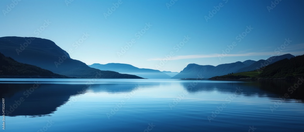 Tranquil body of water with reflections of nature and clear blue sky in a peaceful scenic landscape