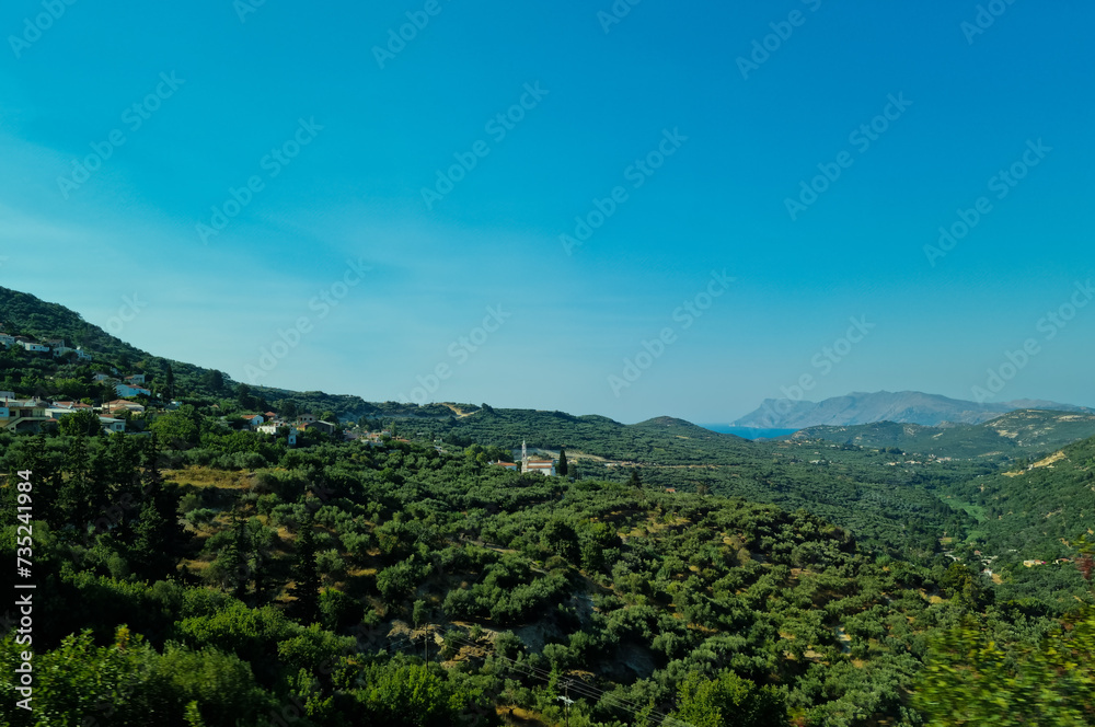 Beautiful view on the island of Crete in Greece. A landscape of olive orchards, mountains and the Mediterranean Sea in the distance. Sunny weather in Crete and plenty of space
