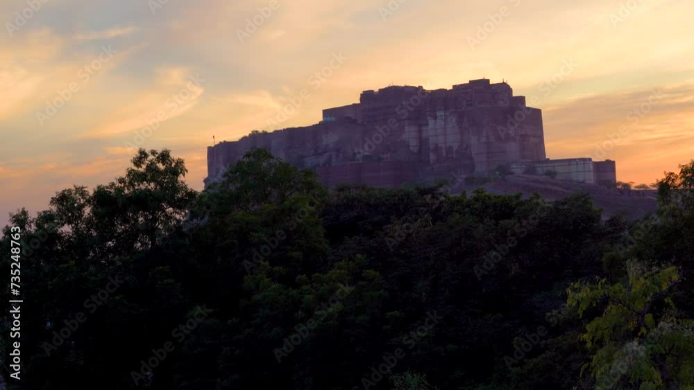 locked shot of the famous mehrangarh fort in Jodhpur Rajasthan sitting on hilltop surrounded by orange monsoon clouds showing the landmark locked shot of the famous mehrangarh fort in Jodhpur Rajasthan sitting on hilltop surrounded by orange monsoon clouds showing the landmark