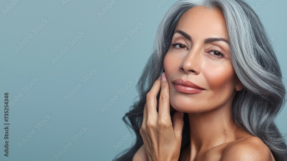 close-up portrait of an elegant senior woman with gray hair, gently touching her face and smiling subtly, set against a neutral background, suggesting a skincare or beauty theme. close-up portrait of an elegant senior woman with gray hair, gently touching her face and smiling subtly, set against a neutral background, suggesting a skincare or beauty theme.