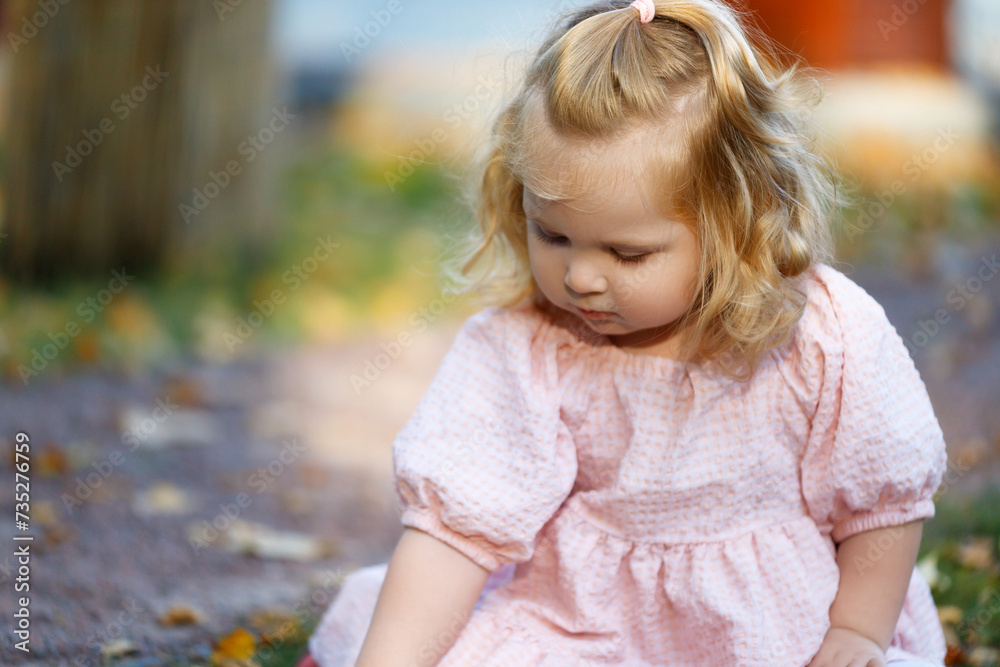 A little girl of 2 years walks in the park and plays. Beautiful child, concept of happiness and well-being. Girl walking with her parents in the park A little girl of 2 years walks in the park and plays. Beautiful child, concept of happiness and well-being. Girl walking with her parents in the park