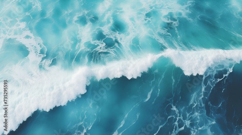 Aerial view of a turquoise ocean wave cresting with white foam against deep blue water photo