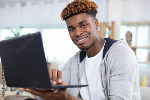 young man at home using a notebook computer © auremar
