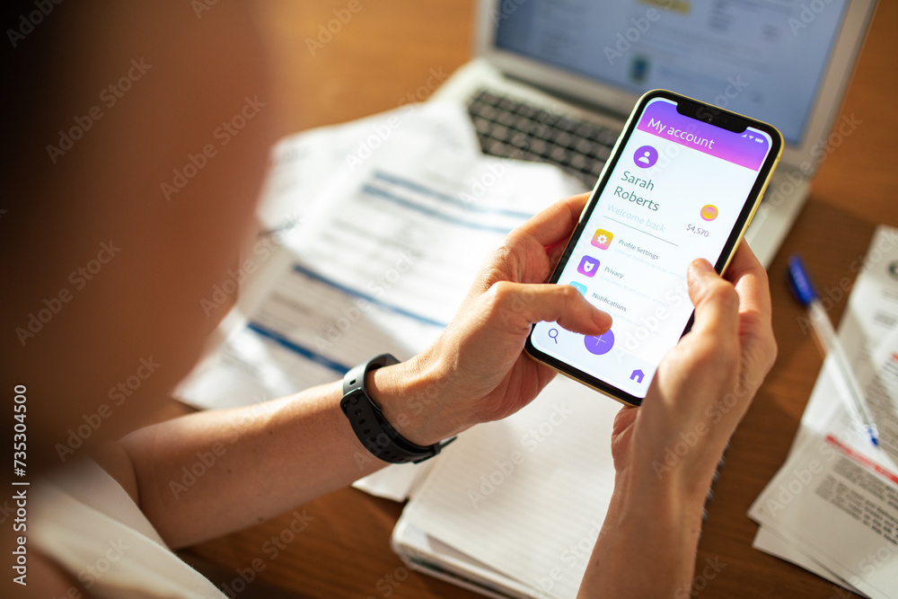 Close up woman checking bank account on smartphone at home Close up woman checking bank account on smartphone at home
