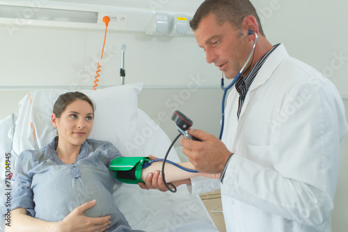 doctor measuring blood pressure of a pregnant woman