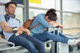 couple with suitcases fallen asleep waiting for public transport