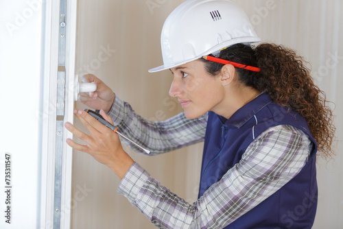 female builder on door knob installation