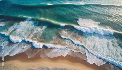 Aerial view of seascape. Blue ocean water with waves. Beautiful sandy beach from drone.