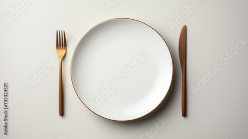 Dining Setup with White Plate and Gold-Trimmed Cutlery