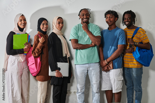 In a vibrant display of educational diversity, a group of students strikes a pose against a clean white background, holding backpacks, laptops, and tablets, symbolizing a blend of modern technology
