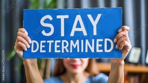 Motivated woman holding  stay determined  sign on abstract background, space for customization.