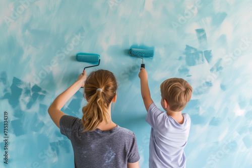 Mother and son painting the wall with paint roller. Home renovation concept.